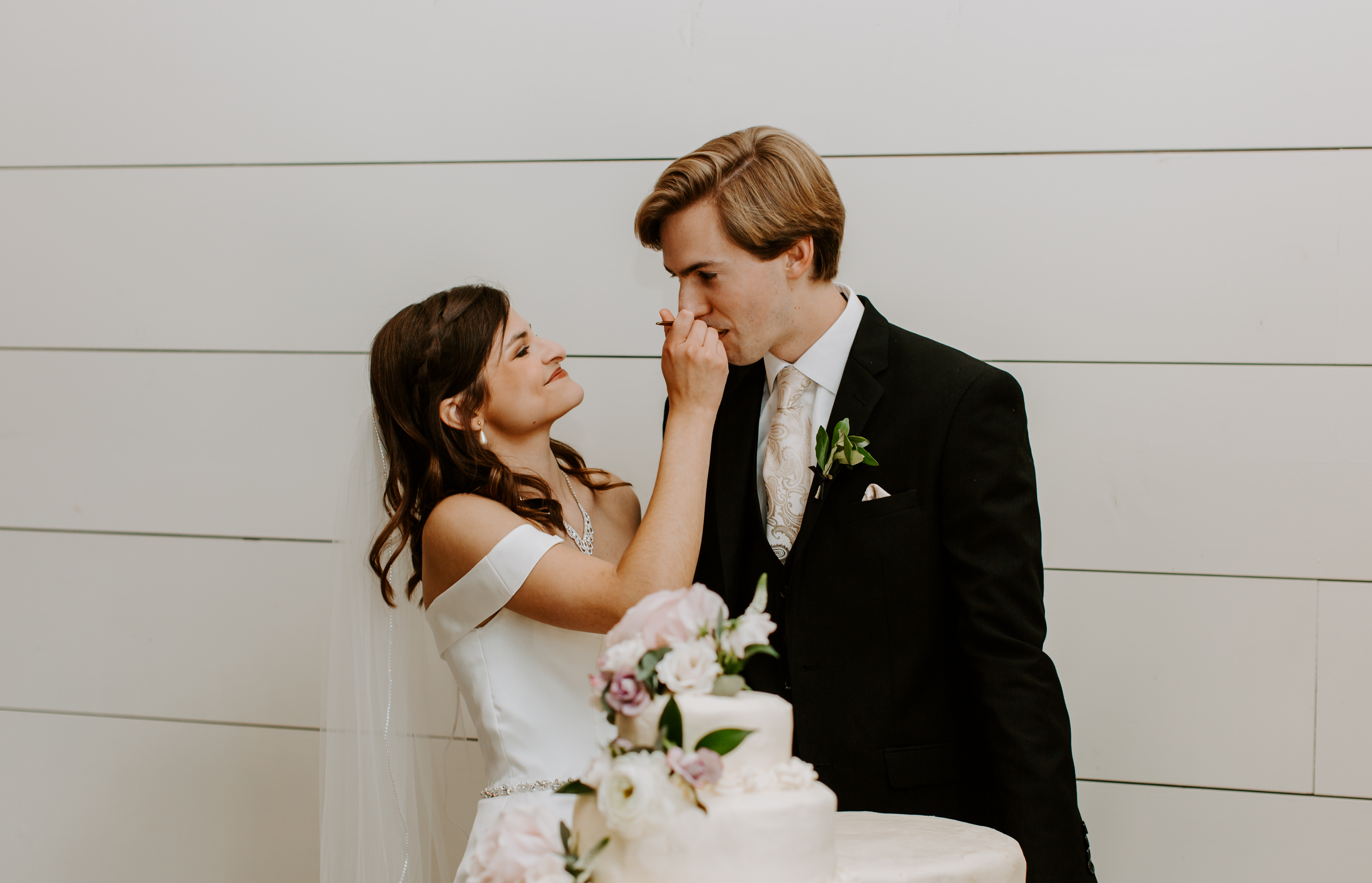 Bride feeds groom cake a Northwest Arkansas wedding