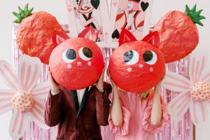 wedding couple with paper mache cat heads held up in front of faces