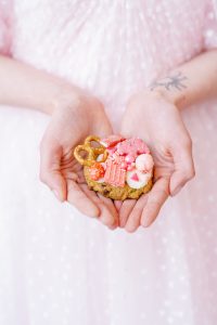 kitschy pink cookie in front of pink wedding dress