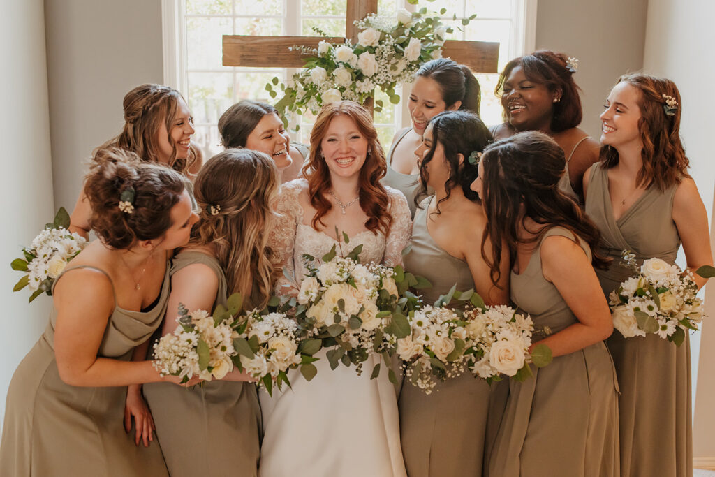 Bride with bridesmaids in front of cross